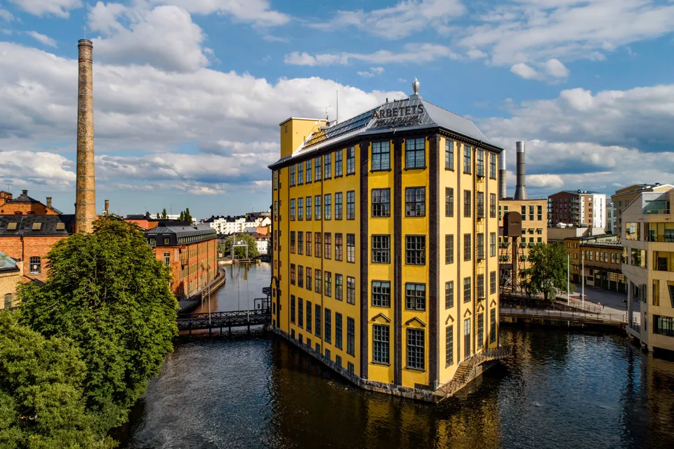 En stor gul byggnad som ligger vid en flod.