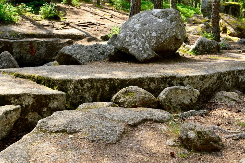 A large rock formation in the middle of a forest.