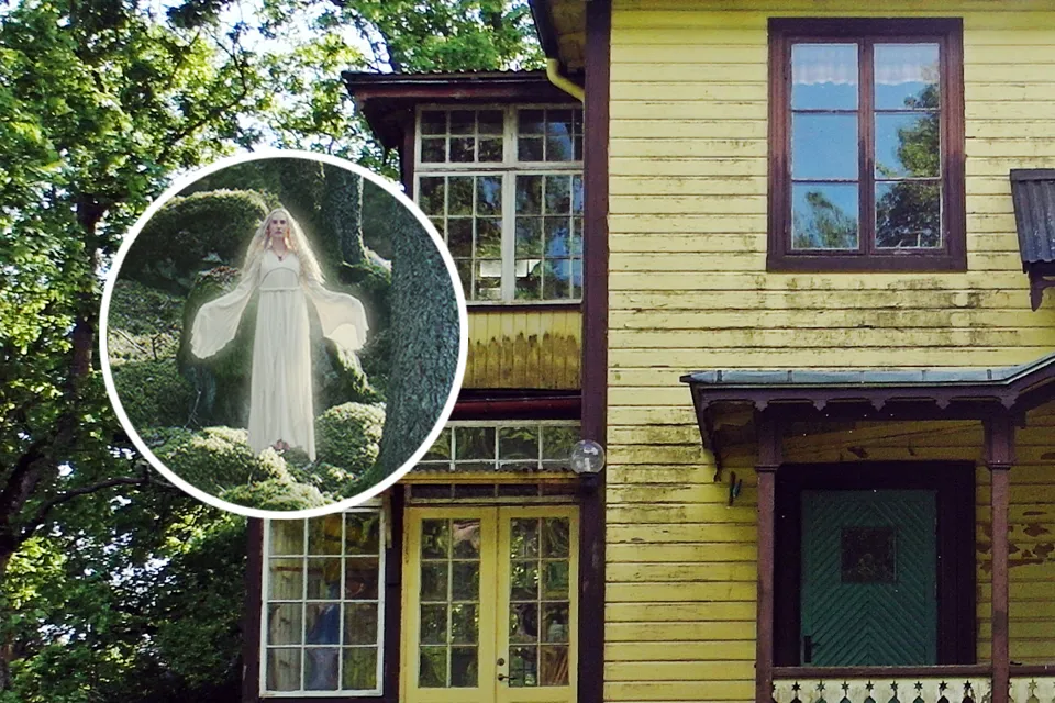 A yellow house with a picture of a woman in a white dress.