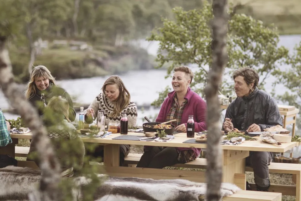 Bild på människor vid bord utomhus