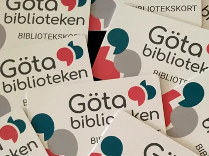 En hög med vita visitkort med röda, blå och gröna prickar.