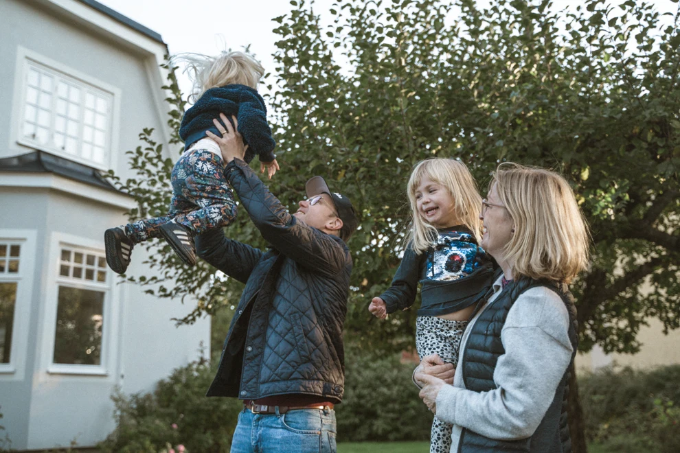 En grupp människor som står framför ett hus.