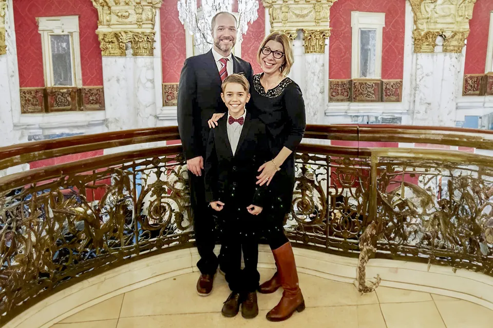 Laura Pompermaier med familj står finklädda under en kristallkrona i en tjusig sal.