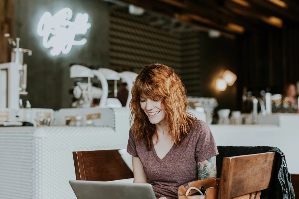 A woman sitting at a table with a laptop.