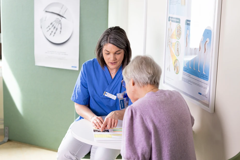Sjuksköterska vid osteoporosmottagningen samtalar med patient.