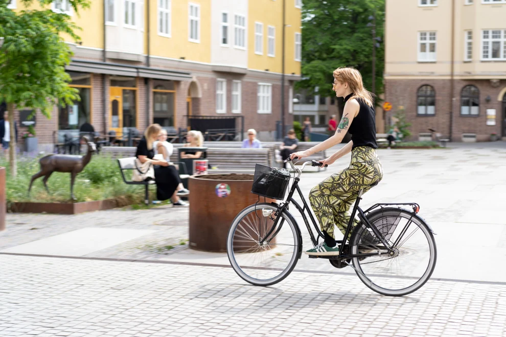 Kvinna som cyklar i en stad