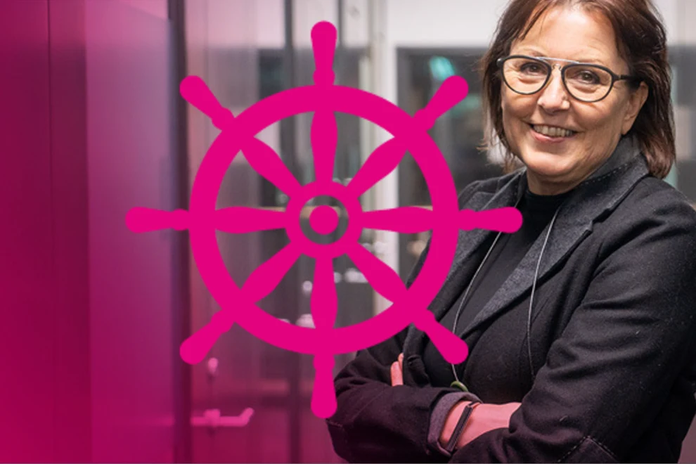 En kvinna som står framför en rosa vägg.