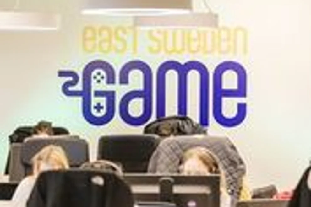 En grupp människor som sitter vid ett bord med bärbara datorer.