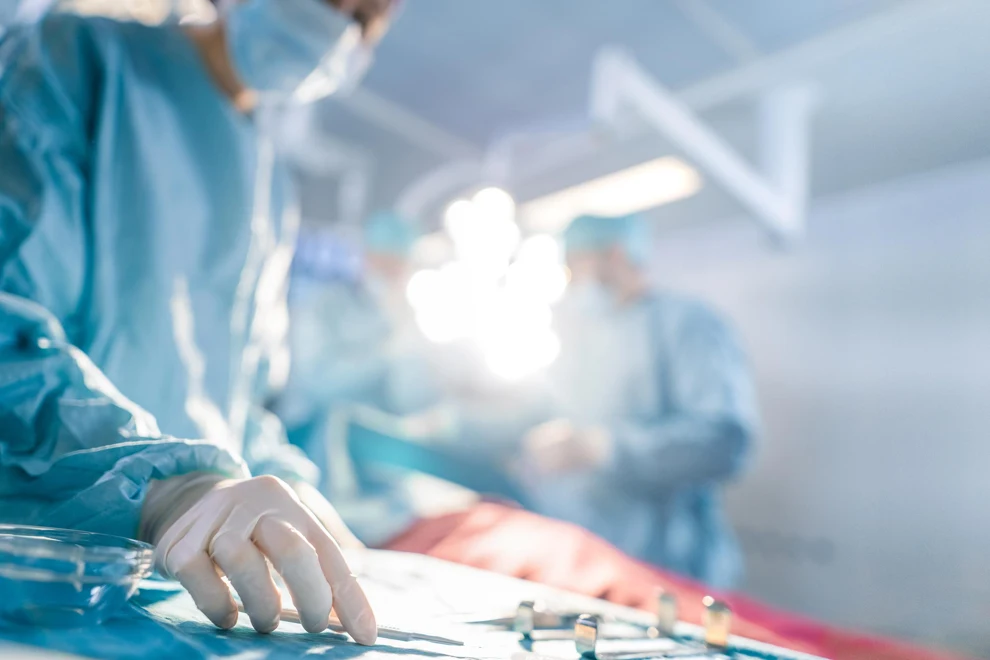 Operationssal med suddiga personer i bakgrunden och instrument i förgrunden